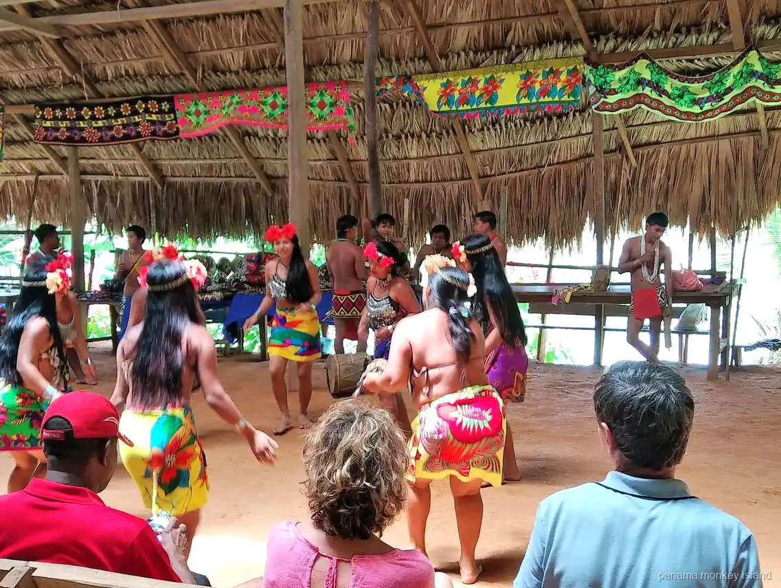Embera dancers in colorful skirts performing for visitors in a village hut, panama monkey island day tour